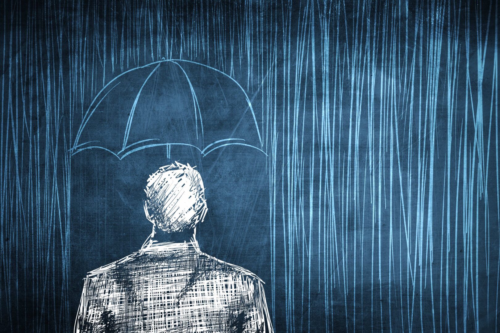 A man standing in the rain with an umbrella.